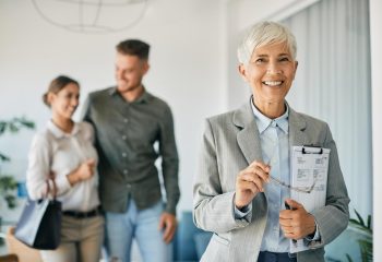happy-mature-insurance-agent-with-her-clients-in-t-2023-11-27-05-11-19-utc